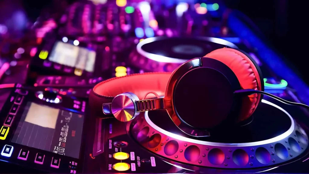 Casque de DJ posé sur une console de mixage éclairée en violet et rose